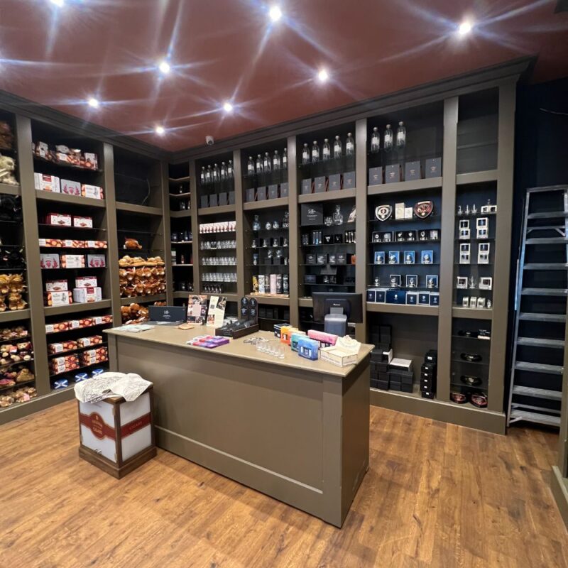 dark olive coloured shelfs displaying products for sale