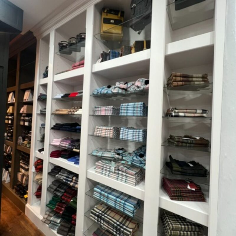 White shelfing displaying shirts in a shop